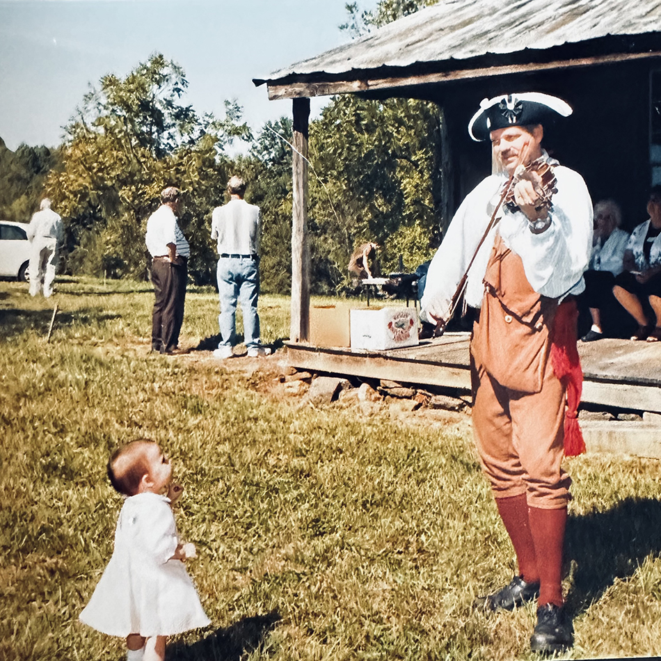 Image of man playing fille while a small child watches